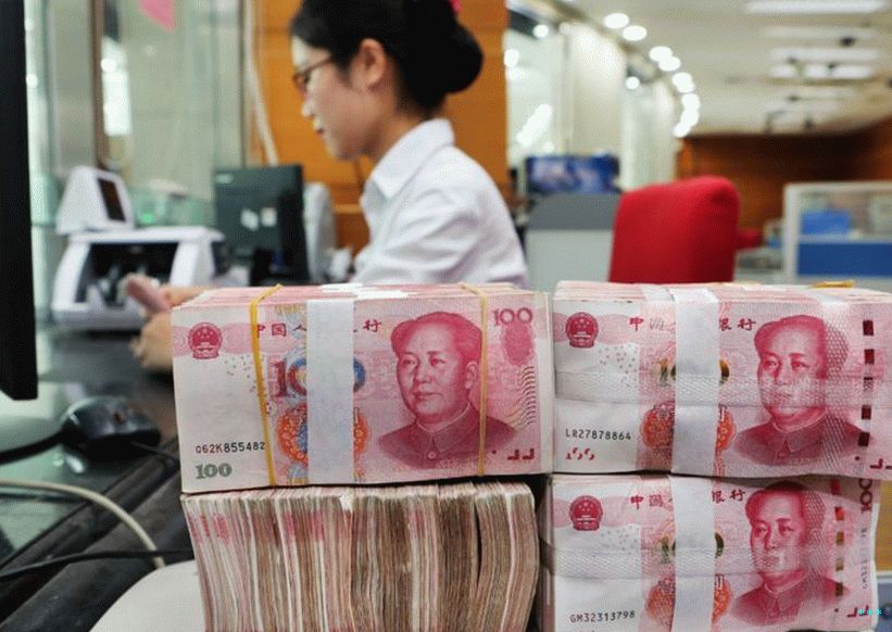 Työntekijä laskee 100 juanin seteleitä Nantongin pankissa Kiinan itäisessä Jiangsun maakunnassa 23. heinäkuuta 2018.